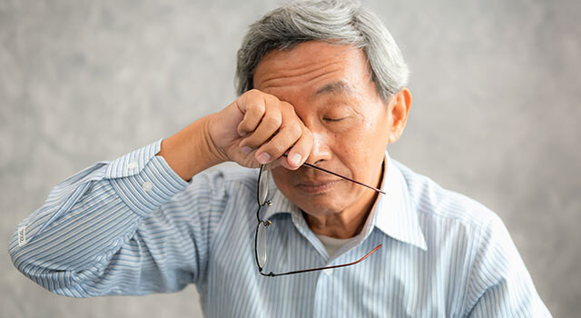 man rubbing eye holding glasses 1.jpg